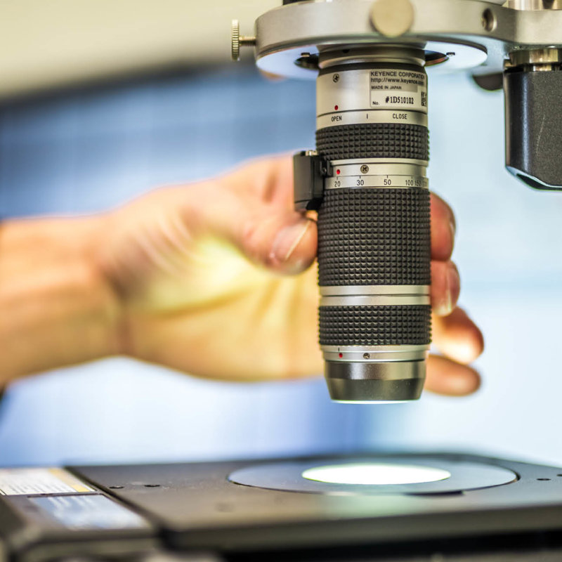 Employee operates microscope