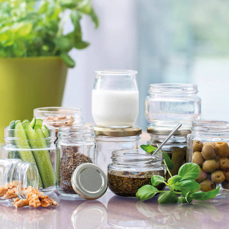 Variety of filled glass jars and plants smbolic for the sustainable advantage of glass