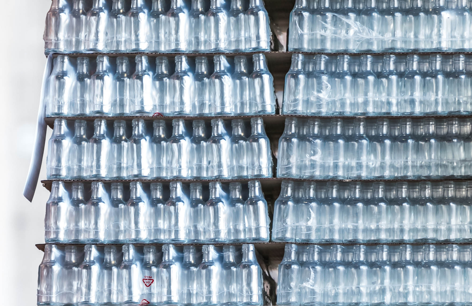 Pallet full of glass bottles packed in shrink packaging