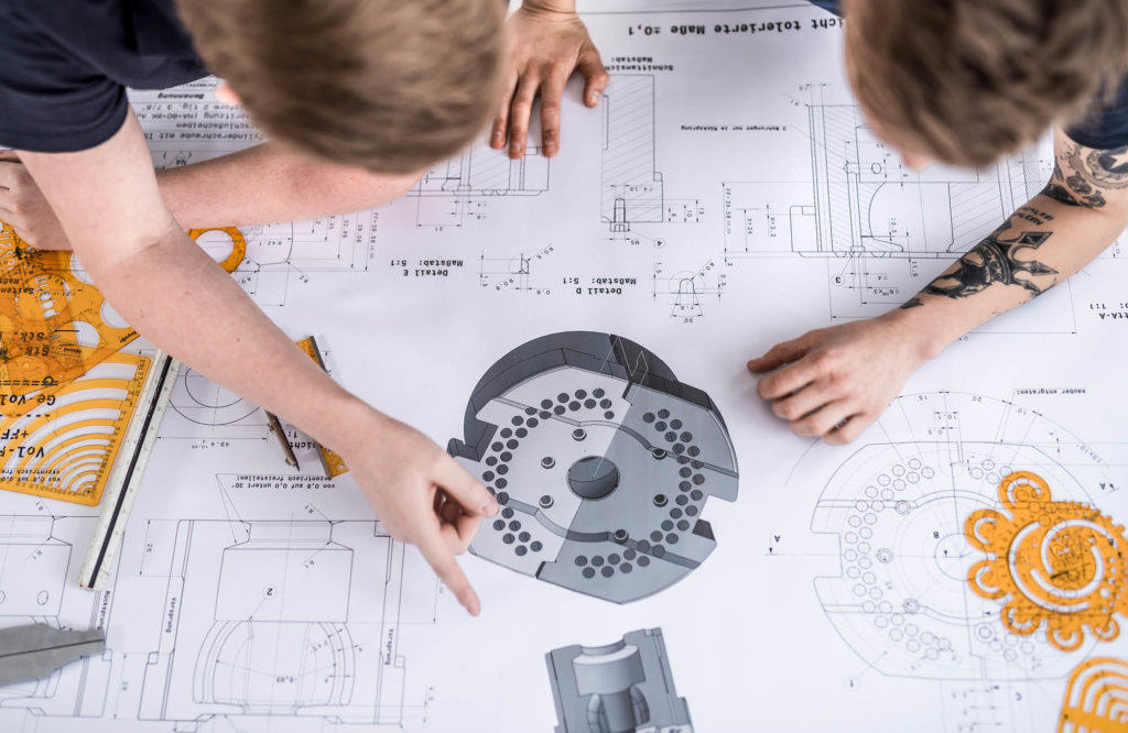 Top view of people working on a mould plan for a new glass shape