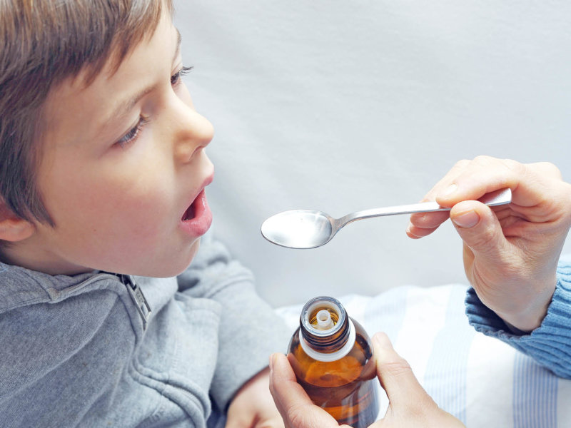 Child gets medicine with a spoon
