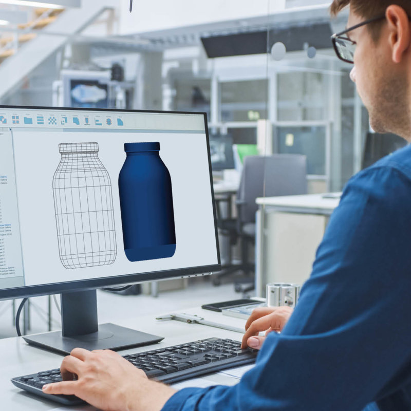 Person sitting in front of the computer designing the new glass bottle