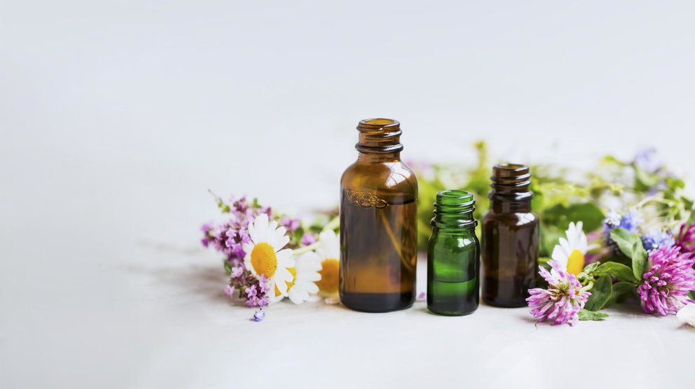 Different dropper bottles surrounded by flowers