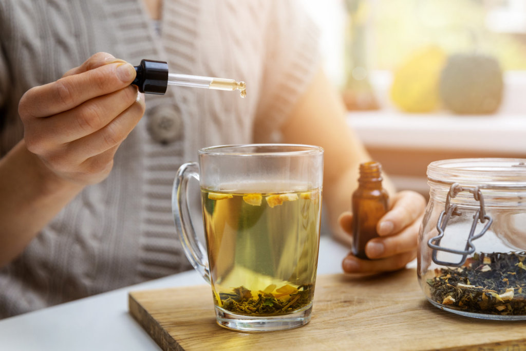 cbd oil drops in tea with herbs