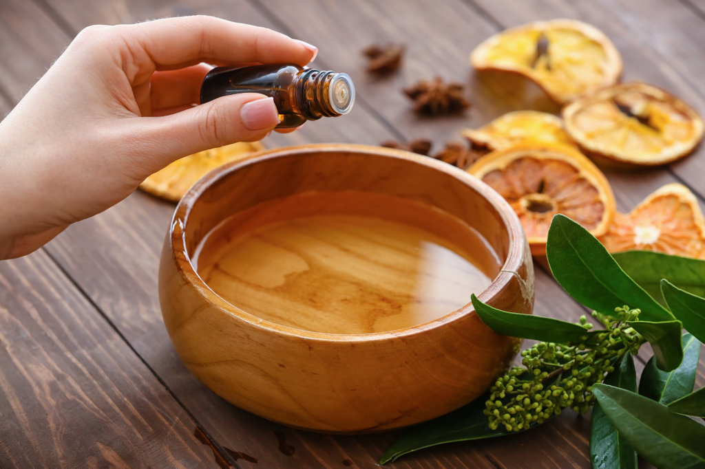 Essential oils dropped into wooden bowl