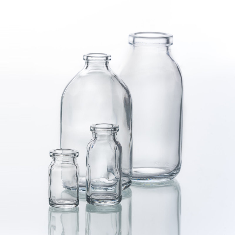 Empty injection and infusion bottles on light background