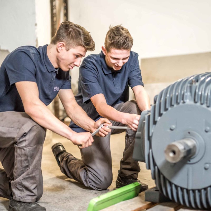 2 technische Lehrlinge arbeiten am Generator