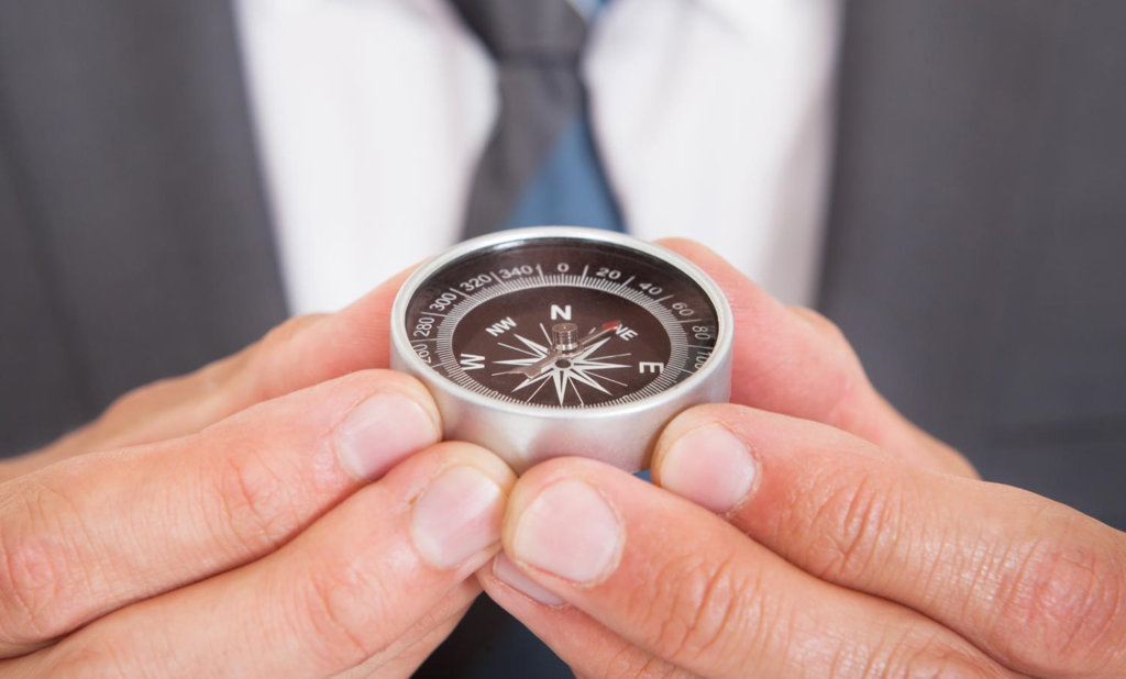 Hand holding a compass