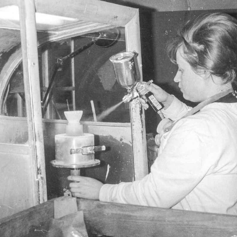 Historic picture of woman spraying glass item in Austrian glass plant