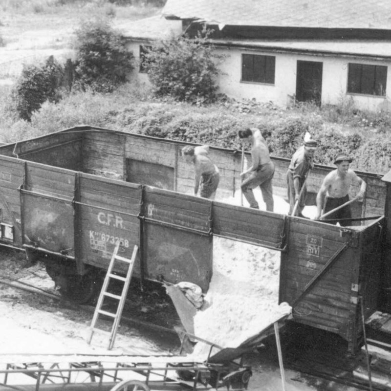 Historic picture of men unloading sand from train at Austrian glass plant