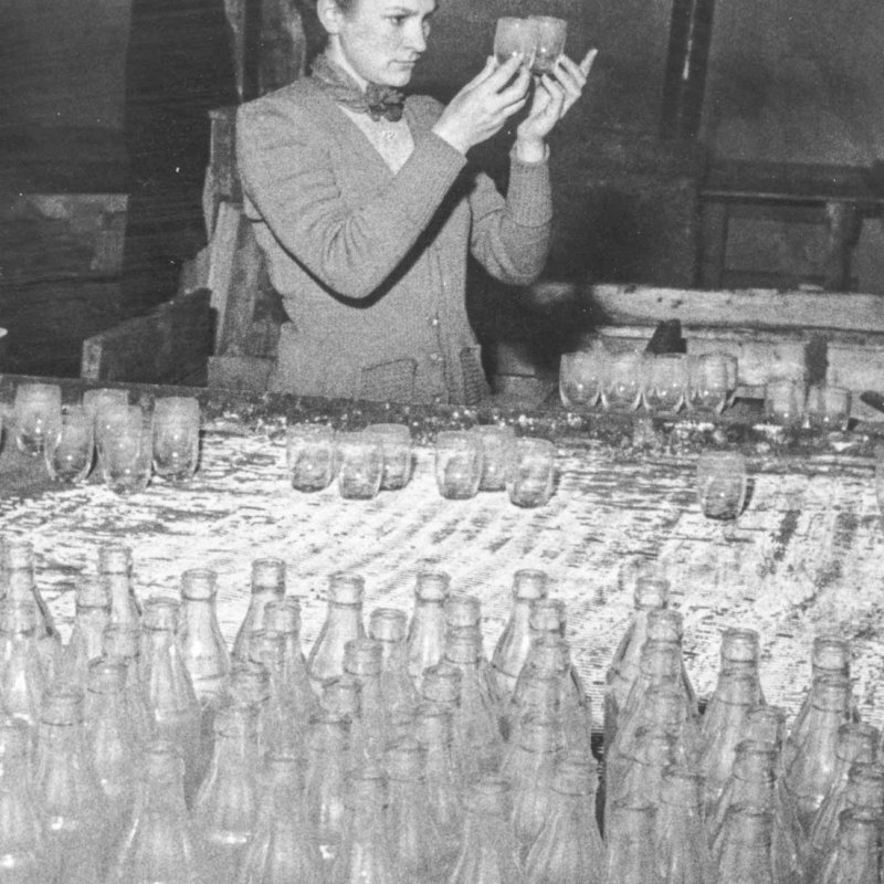 Historic picture of woman checking mouthblown glasses