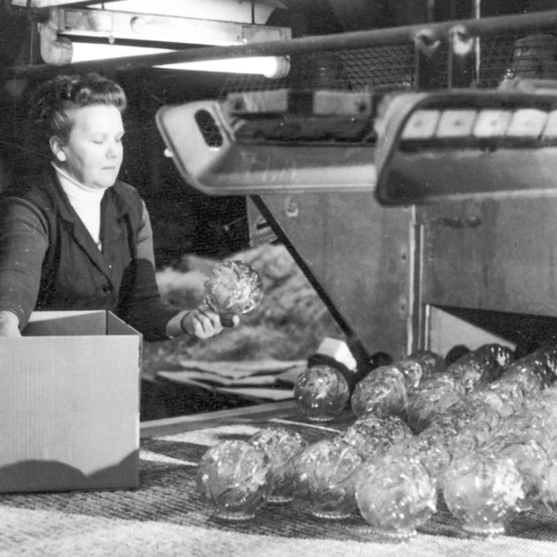 Historic picture of woman checking mouthblown glass lamp